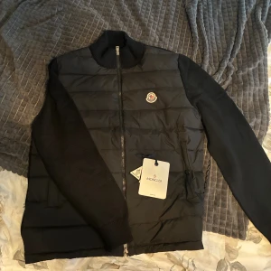 Moncler Cardigan svart - Säljer denna helt nya och fräscha moncler cardigan i färgen svart och storlek M. Fick den som present men då den ej passade så förösker jag att bli av med den. Helt oanvänd endast testad i hemmet. Priset kan diskuteras vid snabbaffär och tveka ej om att höra av dig vid frågor😁