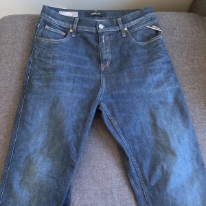 Blå Replay jeans Sandot Relax Tapered - Säljer ett par blå jeans från Replay, modell Sandot Relax Tapered Fit. Klassisk femficksdesign med snygga kontrastsömmar och broderade bakfickor. Jeansen har normal passform och är tillverkade i jeansmaterial med en avslappnad, avsmalnande siluett.