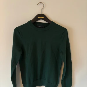 Mörkgrön merinoullströja från Riley - En stilren mörkgrön tröja från Riley i mjuk merinoull. Tröjan är mycket sparsamt använd och passar storlek XS-S! Pris går att diskutera😀