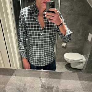 Rutig skjorta från Ralph Lauren - Riktigt snygg rutig skjorta från Ralph Lauren i blått, vitt och grönt. Skjortan är i riktigt bra skick. Hör av er vid funderingar;)