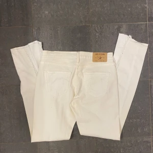 Reworked True Religion jeans W28 – vit bootcut - Reworked Bootcut Unika vita True Religion jeans som jag själv har designat om ✂️ Jag har lagt in tyg från ett annat par jeans längst ner på benen, så de har fått en snygg bootcut-passform istället för skinny. Ger en trendigare, mer avslappnad look 🤍  🧵 One of a kind – ingen annan har likadana! 📏 Midja: ca 34cm 📦 Skick: Mycket bra 💰 Pris: 649 kr 🚚 Skickas snabbt från Sverige 🇸🇪  #TrueReligion #ReworkedJeans #Bootcut #Tjejstil #PlickFinds #UniqueStyle #VintageFashion