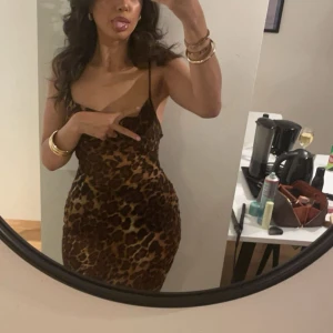 Leopardmönstrad lång klänning  - Säljer en snygg leopardmönstrad Lång klänning med tunna axelband och snörning i ryggen. Klänningen har en tight passform och är gjord i ett lätt, glansigt material som känns lyxigt. Perfekt för dig som vill sticka ut med en djärv look. Längden är lång, för mer bilder fråga 🌺