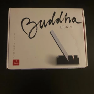 Buddha Board - Buddha Board är ett kreativt ritverktyg där du målar med vatten och ser dina konstverk sakta försvinna. Komplett i originalförpackning med pensel och bricka. Perfekt för avkoppling och mindfulness. Är i mycket bra skick då jag enbart har använt den 2 gånger men själva översidan på kartongen har blivit blöt därav fläcken på kartongen nypris 500