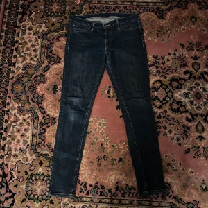 Mörkblå slim jeans från Ralph Lauren denim and supply - Snygga mörkblå slim jeans från Denim & Supply Ralph Lauren med klassiska fem fickor och gul kontrastsöm. Jeansen har en smal passform och är tillverkade i stretchig denim för extra komfort. Perfekta för dig som gillar en stilren och modern look. Midja 42cm längd 103 (66)