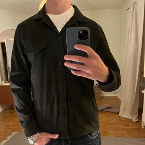 Svart NN07 Overshirt  - Säljer denna sjukt snygga Overshirten från NN07⭐️ Färgen är svart och storleken är M✅ Den har inga defekter och skicket är utomordentligt🙌🤝 Sjukt najs passform och passar perfekt till hösten🍁🙌 Tveka inte på att höra av er dig vid minsta fråga eller fundering😊