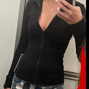 Svart Lululemon define jacket  - Säljer en svart, figurnära zip-tröja från Lululemon med lång ärm och hög krage. Tröjan har dragkedja framtill och är perfekt för träning eller chill. Använd väldigt få gånger och kan tänka mig byta med en annan färg fast samma storlek.