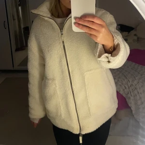 Vit teddyjacka med dragkedja - Beställde denna impulsivt via en annons på sociala medier men när den kom fram så var det för stor för mig. Saknar märke inuti, tagit några promenader i den och den är jätte varm och skön men som sagt för stor för mig, hoppas den passar någon annan. 