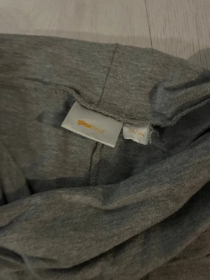Grå bootcut mjukisbyxor Gina Tricot - Snygga grå mjukisbyxor från Gina Tricot i storlek 158/164. Byxorna har en bred, vikbar midja och ett bootcut-snitt som ger en chill vibe. Mjukt och stretchigt material som är skönt att ha på sig hela dagen.