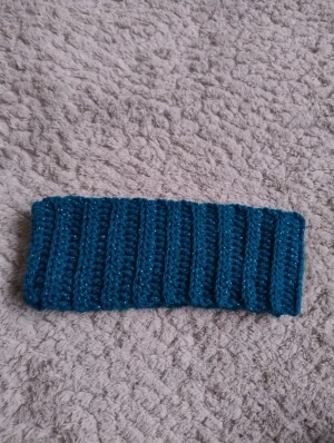 Turkost virkat  pannband med glitter - Snyggt turkost virkat pannband som jag gjort själv. Ribbad design som sitter skönt runt huvudet och ger en cool touch till din look. Perfekt för att hålla öronen varma och samtidigt se stylish ut under kyliga dagar.