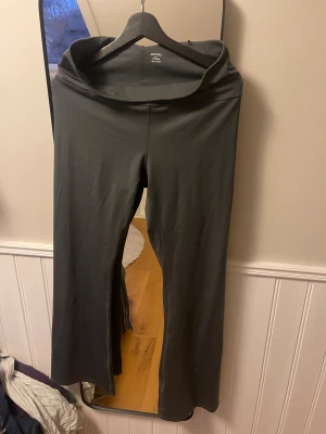 Bootcut byxor  - Säljer ett par grå bootcut byxor från Monki i stretchigt och mjukt material. Väldigt sköna, helt okej längd på mig som är 176. L men passar även mig som är M