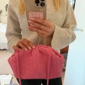 Rosa väska - Säljer en superfin flätad rosa väska med axelrem💖Jättefint skick och bara använd några få gånger🌟den perfekta väskan till en somrig outfit!! Så söt 
