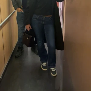 Gina lågmidjade jeans - Snygga blå jeans från ginatricot med bootcut passform och låg midja. Klassisk femficksdesign med vita detaljer på bakfickorna och tydliga sömmar. Jeansen är tillverkade i slitstarkt denim och har en mörkblå ton. Pris kan diskuteras