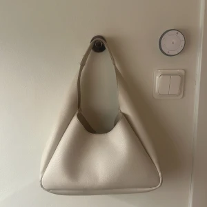 Beige handväska i skinn - Supersnygg, stilren beige handväska med mjuk, slät yta i skinn. 