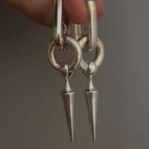 Silvriga örhängen med spetsig hängande detalj - Unika silvriga örhängen från Kappahl.