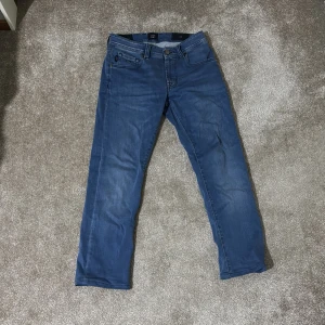  Tramarossa jeans  - Snygga blå jeans från Tramarossa i klassisk femficksmodell. Jeansen har en rak passform och är tillverkade i mjukt denimtyg med subtila slitningar. Midjan är normal och detaljerna inkluderar logopatch baktill och metallknappar. Perfekt för dig som gillar stilrena jeans.