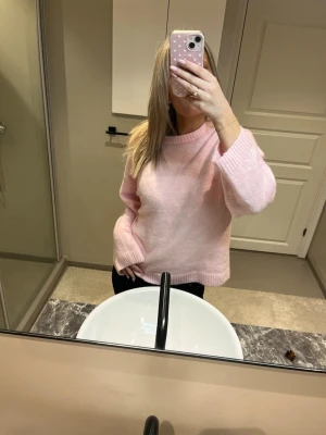 Ljusrosa stickad tröja - Mysig ljusrosa stickad tröja med rund hals och breda ribbade muddar vid ärmslut och nederkant. Ej använd 