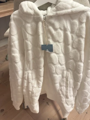Vit fluffig Firefly hoodie - En vit fluffig zip hoodie från märket firefly. Aldrig använd med prislapp kvar. Lappen är avklippt eftersom att det var en present och priset inte skulle synas.