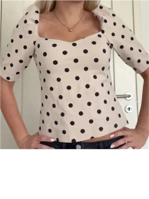 Prickig topp med puffärm från H&M - Jättesöt topp ifrån hm, första bilden är för att visa hur den sitter på, men säljer den som är svart med vita prickar💓Storlek är M men passar mig som brukar ha xs-s
