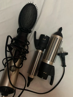 OBH Nordica varmluftsborste med tillbehör - Säljer en OBH Nordica varmluftsborste i metallic och svart med flera utbytbara borsthuvuden och en diffuser. Perfekt för att styla och forma håret med olika looks. Borstarna har mjuka piggar och är gjorda av plast och metall.