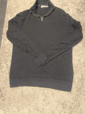 Svart långärmad tröja med half zip - Svart långärmad tröja från Jack & Jones med ribbade muddar och krage med half zip-dragkedja. Perfekt för dig som gillar en stilren look med en sportig touch. Passar till både jeans och chinos.