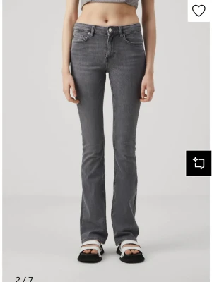 Grå bootcut jeans från Only - Snygga grå jeans från Gina Tricot med bootcut passform och klassisk femficksdesign. Jeansen har hög midja och är tillverkade i mjukt stretchigt denimmaterial som sitter skönt. Perfekta för dig som gillar en stilren look med lite retrovibe. Storlek L/34