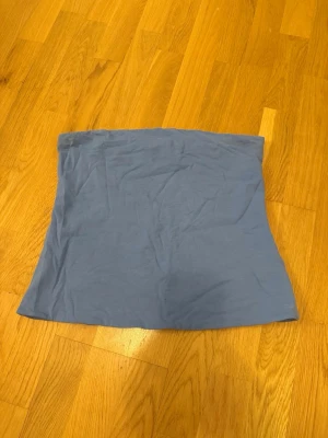 Blå tubtopp från zalando - Säljer en enkel och stilren blå tubtopp från zalando. Toppen är axelbandslös och har en rak, bandeauformad siluett. Tillverkad i mjukt och stretchigt material som sitter skönt mot kroppen. Perfekt att matcha med jeans eller kjol. storlek M