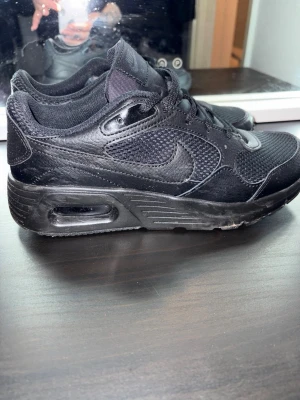 Svarta Nike Air sneakers strl 39 - Säljer ett par helsvarta Nike Air sneakers i storlek 39. Skorna har en snygg mesh och skinnmix med klassisk Nike-logga på sidan. De har snörning och en platt sula med synlig Air-enhet. Perfekta för dig som gillar sportig och clean stil. Nypris 850. Nyskick knappt använda.