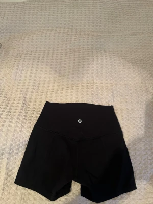 Svarta träningsshorts från Lululemon - Har ingen lapp kvar, men passar en XS/S! Något korta shorts och är heltsvarta som på första bilden (de andra bilderna är i annat ljus). Sköna och fina, från Lululemon!