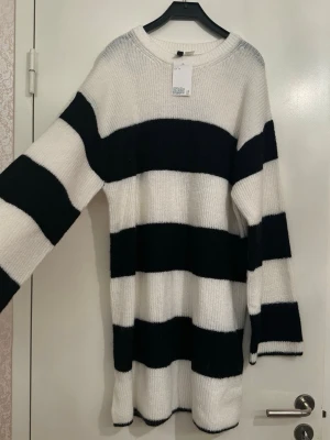 NY Randig stickad tröja - Oversized stickad tröja. Ordinarie 329kr. Säljs inte längre. Tröjan har breda svarta och vita ränder, rund hals och långa ärmar. Materialet är mjukt och stickat, perfekt för att chilla eller hänga med kompisar. Snygg att bära till jeans eller leggings. 