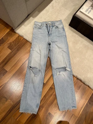 Raka jeans - Raka jeans med hål vid knäna från Gina tricot i storlek 30