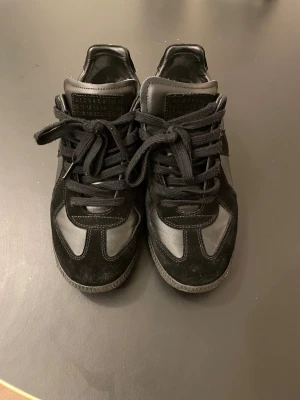 Maison margiela gats - Säljer nu ett par feta svarta Maison margiela gats i storlek 43, allt ingår så som skolådan och skopåsar!! De är inte äkta! Men är ändå lika bra kvalité!