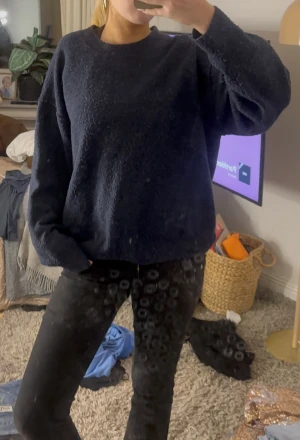 Mörkblå stickad tröja - Mysig mörkblå stickad tröja med rund hals och långärmad passform. Tröjan har en loose fit och är perfekt för kyligare dagar. Enkel och stilren design som är lätt att matcha med olika outfits.