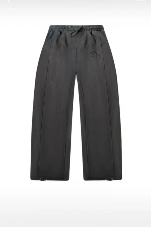 Dreamz| Svarta wide mjukisbyxor med snörning - Svarta mjukisbyxor med breda ben och snörning i midjan. Byxorna har en broderad logga på höften och raka sömmar längs benen. Perfekt för chill dagar och streetwear-stil. Alla storlekar finns | XS-XL  100% Bomull med mjuk bekväm insida org pris 699kr