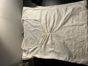 Vit kortärmad klänning från 157 - Enkel och stilren vit klänning från 157 i mjuk bomull. Modellen är kortärmad med lätt rynkdetalj framtill som ger en snygg form. Perfekt för dig som gillar minimalistisk och clean stil.