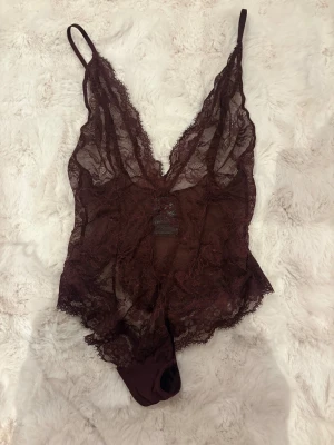 Spets body i Burgundy  - Oanvänd spets body med låg v ringning i en fin Burgundy färg från HM
