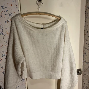 Vit kort stickad tröja H&M - Supermysig vit stickad tröja från H&M med kortare passform och bred ribbad kant vid halsen. Tröjan har långa ärmar och kan användas of shoulder om man önskar på en eller två ärmar!