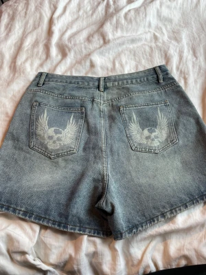 Blå denimshorts med döskalletryck - Shorts med dödskalletryck på bak fickorna aldrig använda