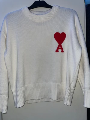 Vit stickad tröja från Ami Paris - Vit stickad tröja från Ami Paris som säljs då den ej kommer till användning, bara att höra dig vid frågor och funderingar!