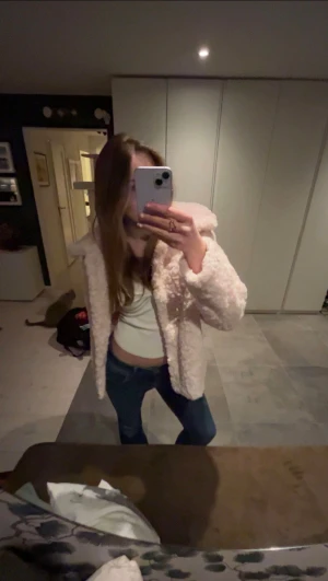 Ljusrosa teddyjacka med huva - Supermjuk ljusrosa teddyjacka. Super fluffig och mysig, perfekt för kyligare väder. Knappar framtill och har långa ärmar. As snygg att matcha till allt. Passar s-l!