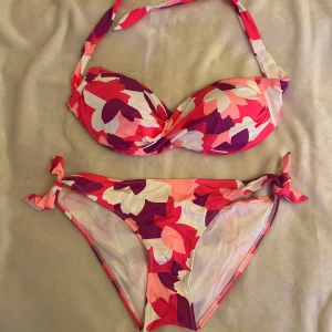 Bikini  - Helt ny, oanvänd bikini i rosa/vit/lila färg, storlek M. Bikinin är mjuk och skön med bra passform.🩷