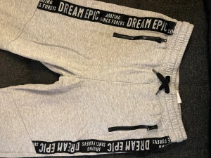 Grå mjukisbyxor - Grå mjukisbyxor från H&M med svart snörning i midjan och ribbade muddar vid benslut. Storlek M (barn)