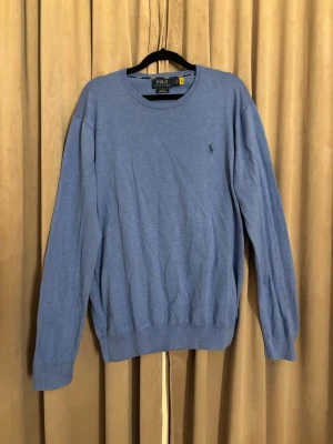 Ralph Lauren tröja - Ljusblå crewneck sweater från Ralph Lauren.  Storlek L, slim fit, så mindre i storleken.                        Använd fåtal gånger, nyskick, original pris: ca 1500.