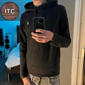 Ralph Lauren hoodie  - Svart hoodie från Ralph Lauren med klassisk vit logga på bröstet. Tröjan har huva med snörning och långa ärmar. Perfekt för dig som gillar en enkel och stilren look.