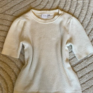 Vit stickad tröja från Vila - Cremevit kortärmad stickad tröja från Vila i storlek XS. Bara använd fåtal gånger. 