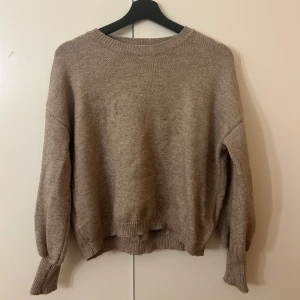 Beige stickad tröja med rund hals - Mysig beige stickad tröja med rund halsringning och ribbade muddar. Tröjan har en loose passform och långa ärmar. Storlek vet jag inte eftersom att lappen är borta💞Men skulle gissa runt S!