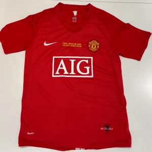 Manchester United Ronaldo 7 Finaltröja - Manchester Uniteds officiella finaltröja från Champions League-finalen 2008 i Moskva. Röd med broderat klubbmärke, gult finaltryck, AIG-logga och Ronaldo 7 i silver på ryggen. Tillverkad i lätt och ventilerande polyester, klassisk passform och korta ärmar. Storleken är S men passar även M. Om det finns frågor och funderingar är det bara att höra av sig