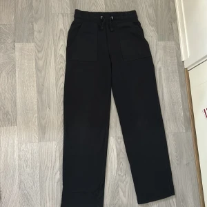 Svarta mjukisbyxor från lager 157, storlek XS - Svarta mjukisbyxor från lager 157 i storlek XS. Byxorna har resår i midjan med snörning, raka ben och stora fickor både fram och bak. Perfekta för chill dagar eller när du vill vara extra bekväm. De är även sköna att ha på sig. 