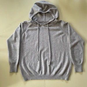 Kashmir hoodie - Mysig, mjuk stickad hoodie i kashmir, beige med långa ärmar och dragsko i huvan. Tröjan har ribbade muddar och avslut, perfekt för lager på lager under kyliga dagar. Enkel och stilren design som funkar till det mesta. Passar dig som är 160-175 lång. 