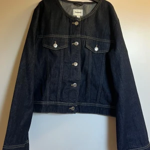 Cropped jeansjacka från Kappahl - Snygg mörkblå jeansjacka från Kappahl med rund halsringning och vida armar. Säljer då den inte kommer till användning, köpte för en månad sedan och bara använt den en gång. Jackan är i storlek S och färg Mörk denim. NYPRIS:699kr (använt både mina egna bilder och bilder från Kappahls hemsida) 