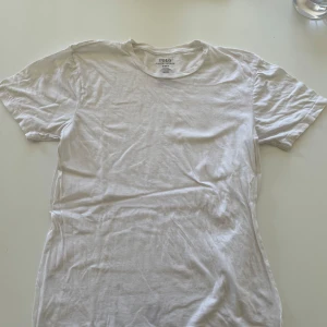 Vit t-shirt från Polo Ralph Lauren - Klassisk vit t-shirt från Polo Ralph Lauren i 100% bomull. Modellen har rund halsringning och korta ärmar, perfekt basic-plagg med clean look. Passformen är classic fit och materialet är mjukt och skönt mot huden.